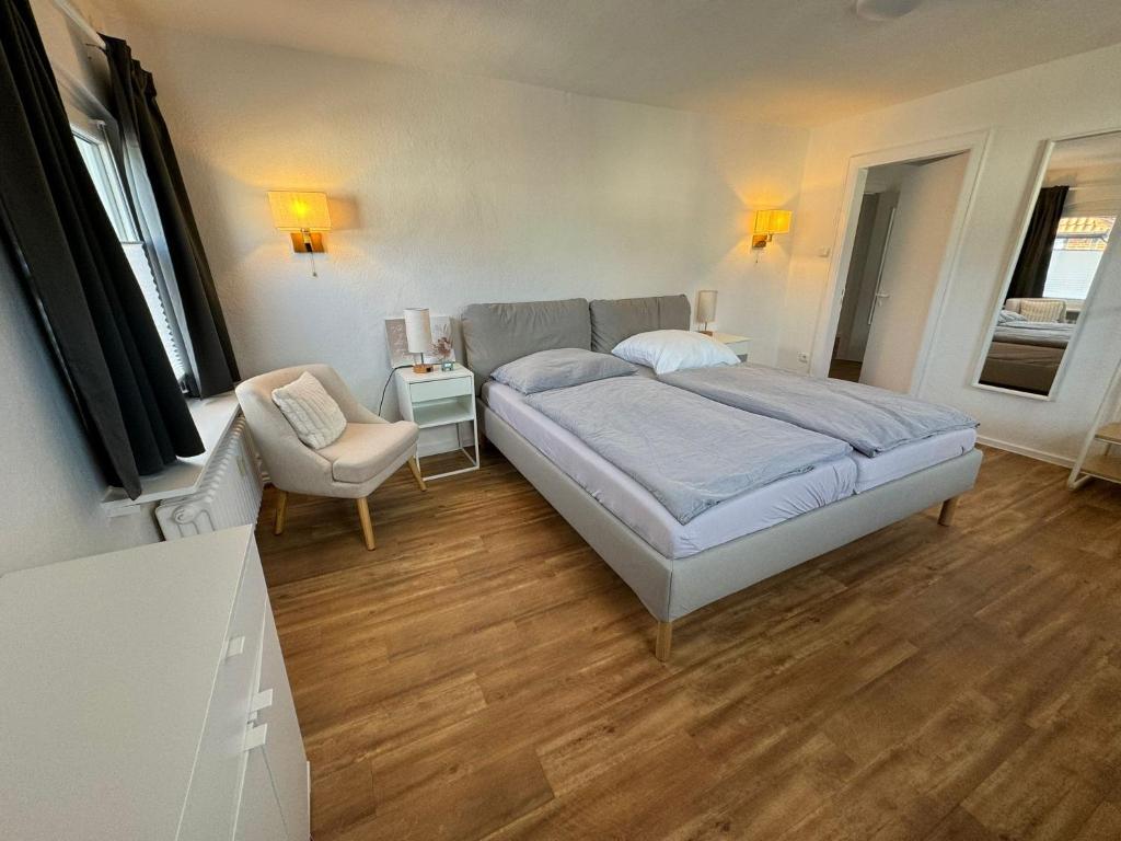 a bedroom with a bed and a chair at Buxtehude Altstadt Wohnung 84qm für 6 Personen in Buxtehude