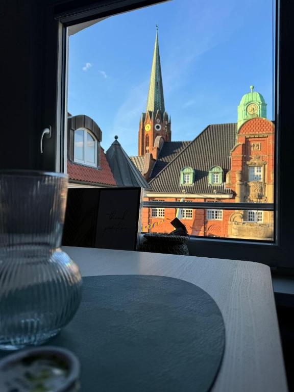 a table with a window with a view of a church at Buxtehude Altstadt Wohnung 84qm für 6 Personen in Buxtehude