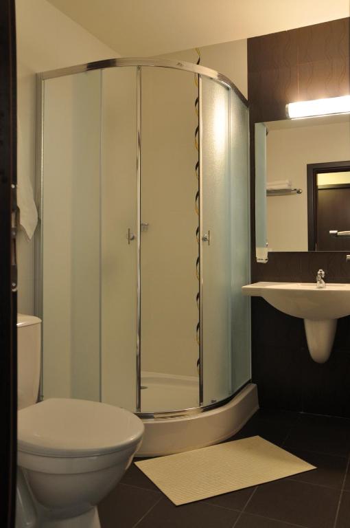 a bathroom with a shower and a toilet and a sink at Hotel Burgas Free University in Burgas