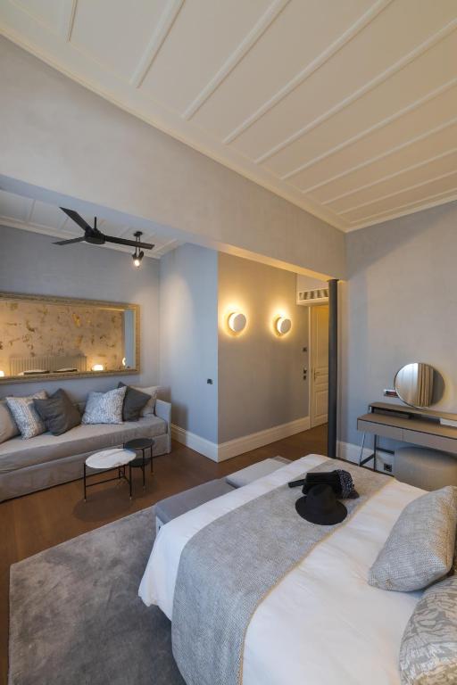 a hotel room with two beds and a couch at Castellano Hotel & Suites in Nafplio