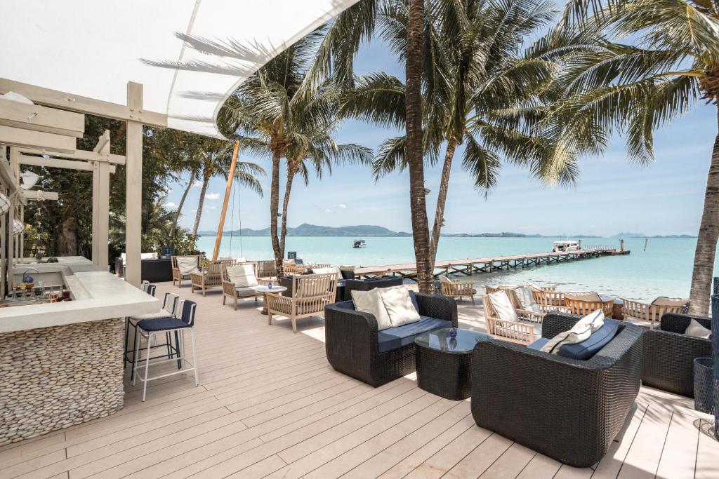 a resort patio with chairs and a view of the ocean at Barcelo Coconut Island, Phuket in Phuket Town