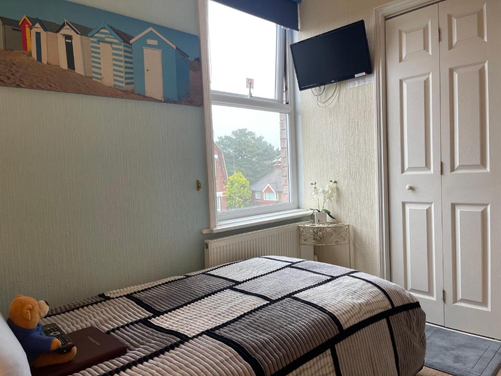 a bedroom with a bed and a window at Arun Sands Rooms in Littlehampton