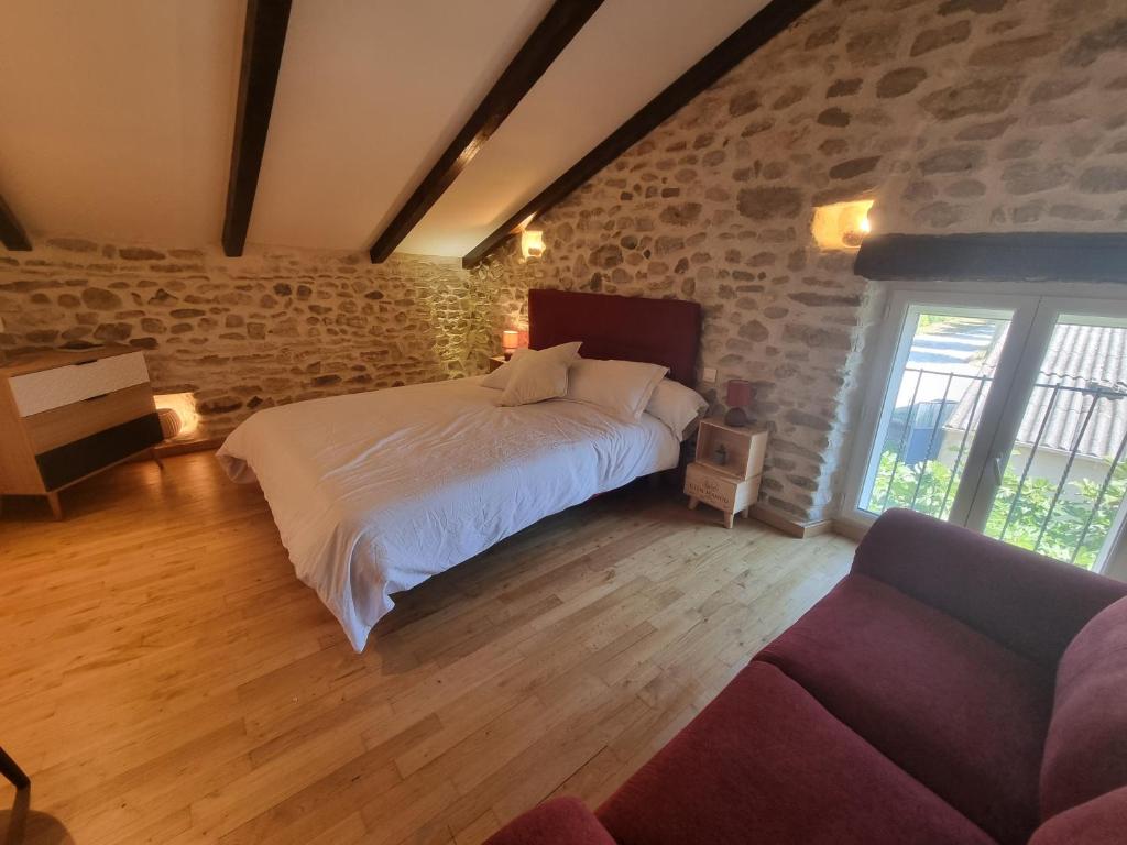 a bedroom with a large bed and a couch at L'Oustau de Maître Potager in Valréas