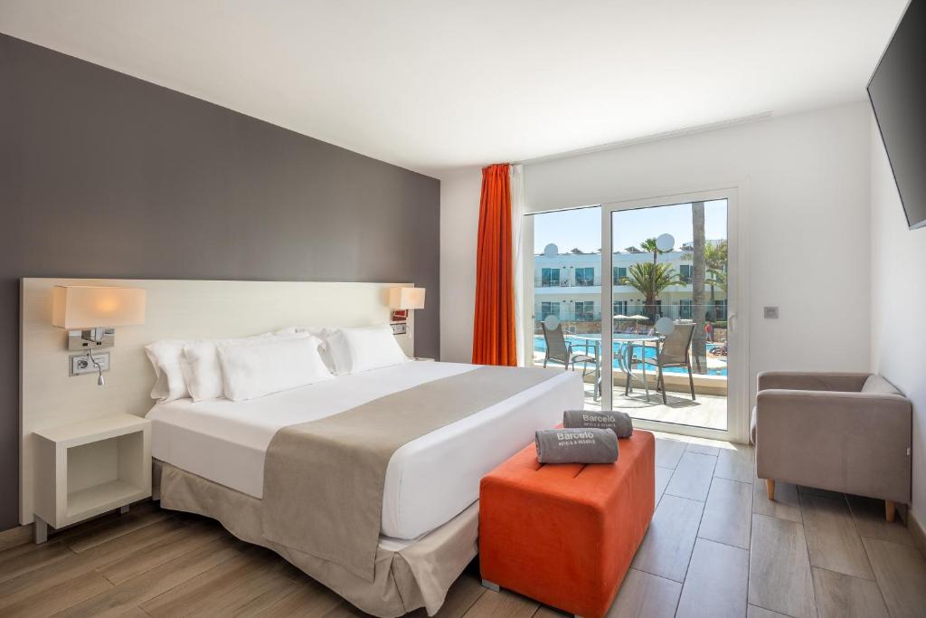 a bedroom with a large bed and a balcony at Barceló Corralejo Sands in Corralejo