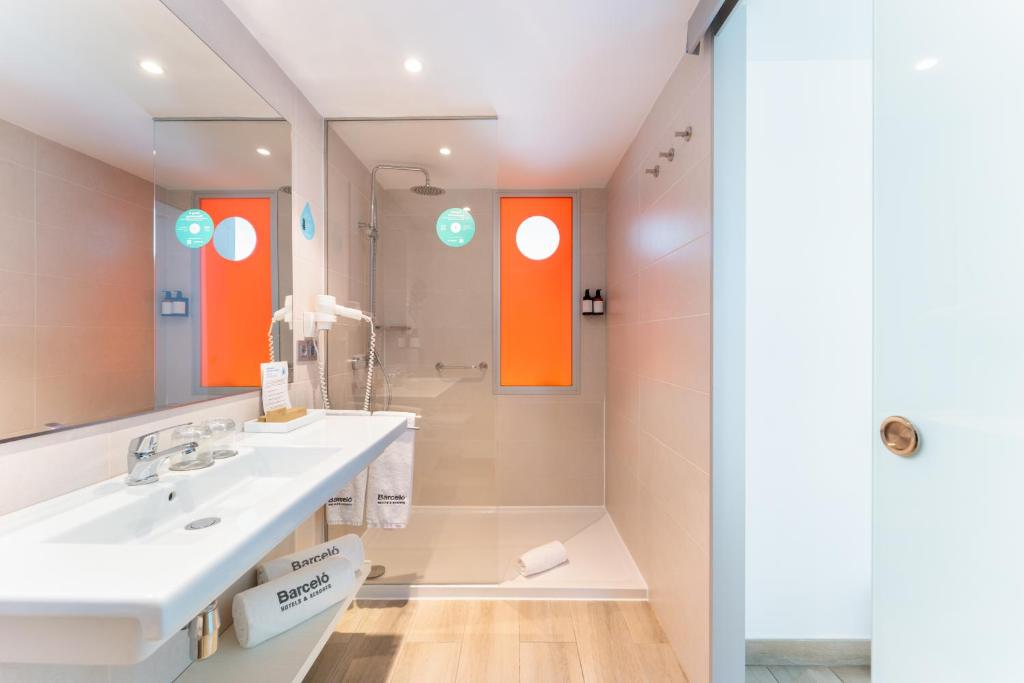 a bathroom with a sink and a mirror at Barceló Corralejo Sands in Corralejo