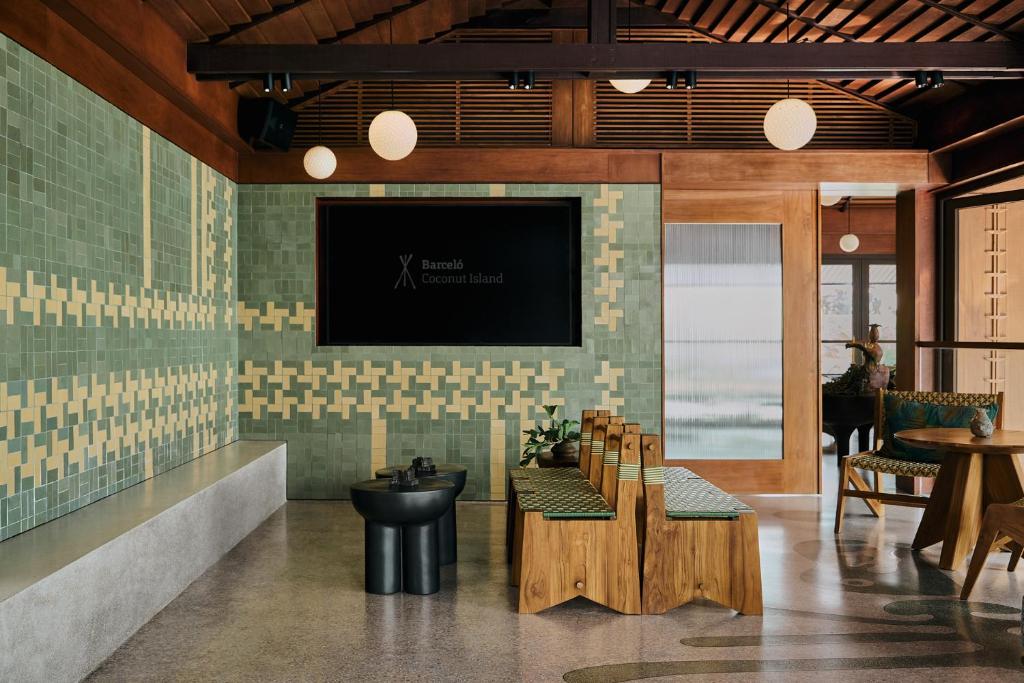 a room with a tv on a wall with a table at Barcelo Coconut Island, Phuket in Phuket Town