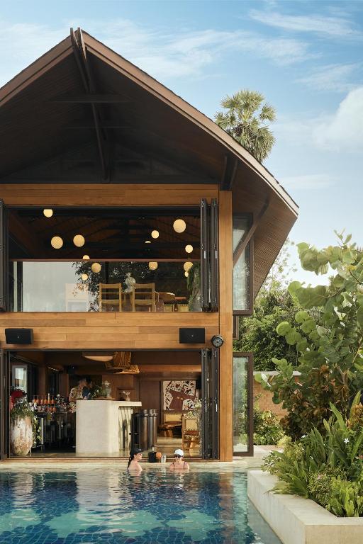 a house with a swimming pool in front of it at Barcelo Coconut Island, Phuket in Phuket Town
