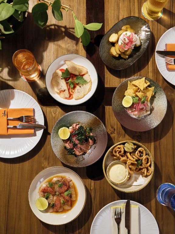a wooden table with plates of food on it at Barcelo Coconut Island, Phuket in Phuket Town