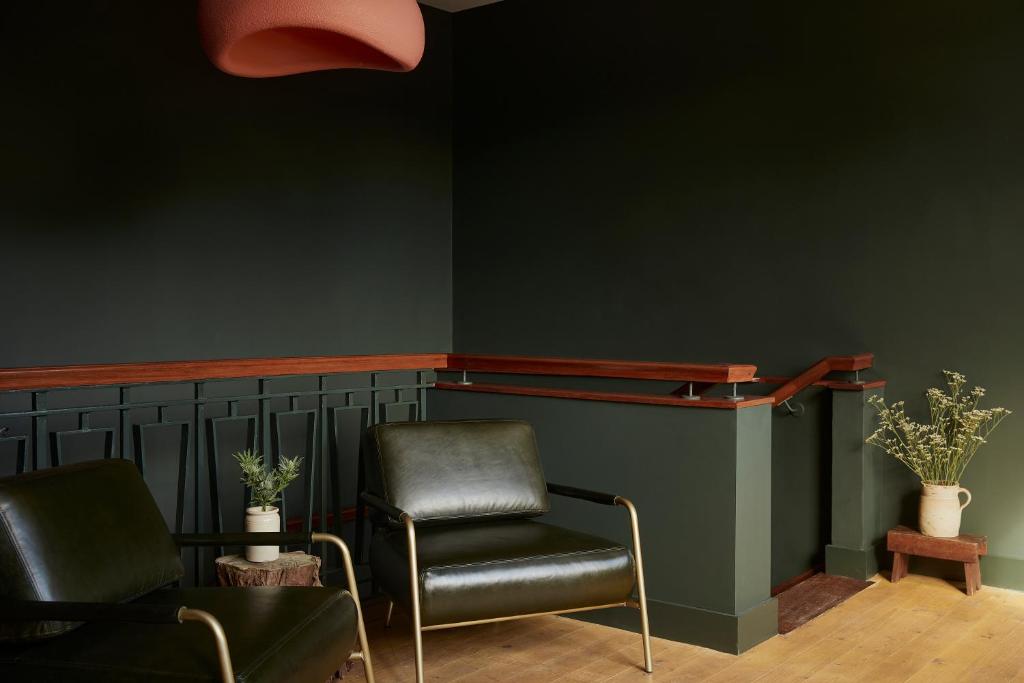 une salle d'attente avec deux chaises et un mur vert dans l'établissement Yarn - Romy Deluxe Apartment, à Ballycastle