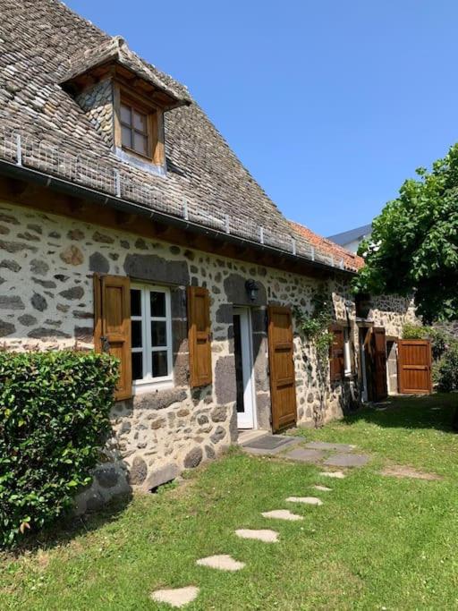 Cette ancienne maison en pierre est dotée de portes en bois et d'herbe. dans l'établissement Gîte de Lagarde, à Saint-Cernin