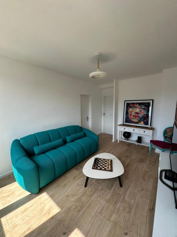 un salon avec un canapé bleu et une table dans l'établissement Appartement des calanques, à Marseille