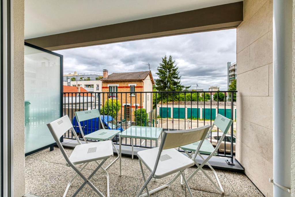 einen Balkon mit Stühlen, einem Tisch und einem Pool in der Unterkunft Moulin à Vent A14 - Appt pour 4 avec balcon in Bondy