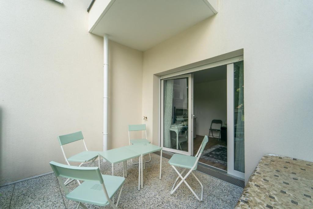 une table et des chaises dans une pièce avec une fenêtre dans l'établissement Moulin à Vent A03 - Studio avec terrasse, à Bondy