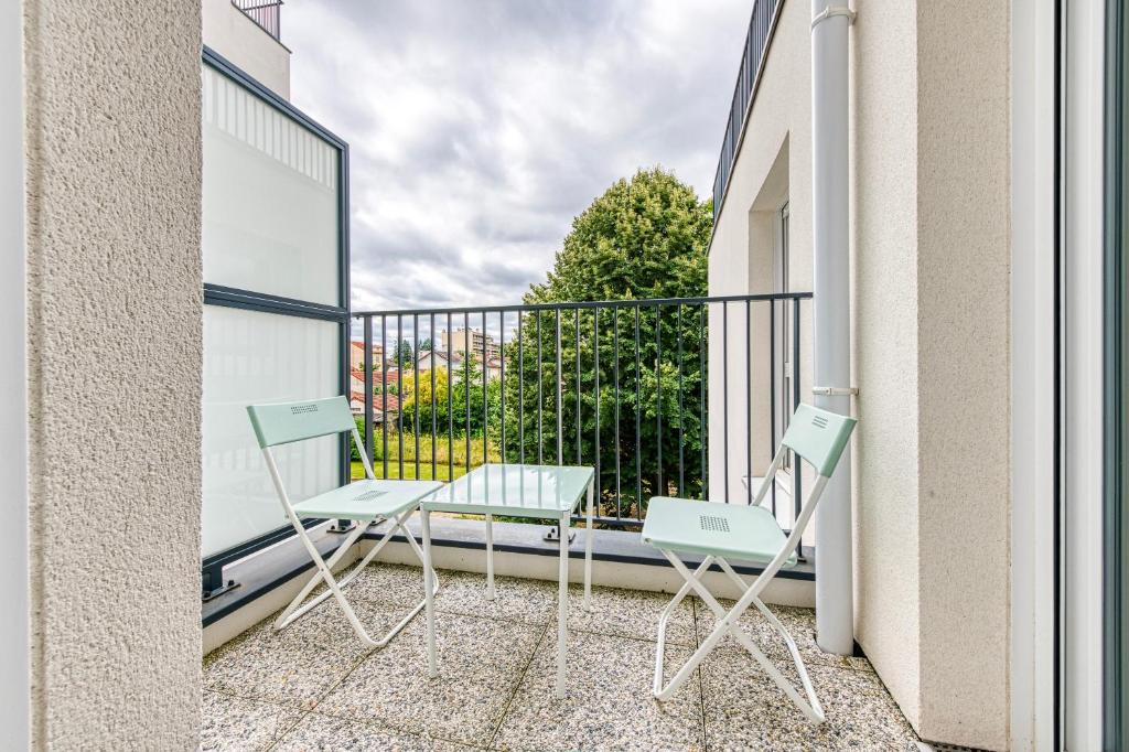 einen Balkon mit zwei Stühlen und einem Tisch darauf in der Unterkunft Moulin à Vent A21 - Appt pour 4 in Bondy