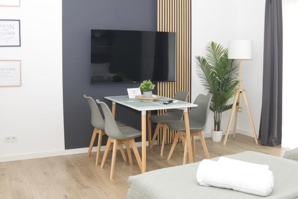 ヴォルフスブルクにあるGRAzzOO 3 getrennte Zimmer 3x Smart TVのテーブルと椅子とテレビのあるダイニングルーム