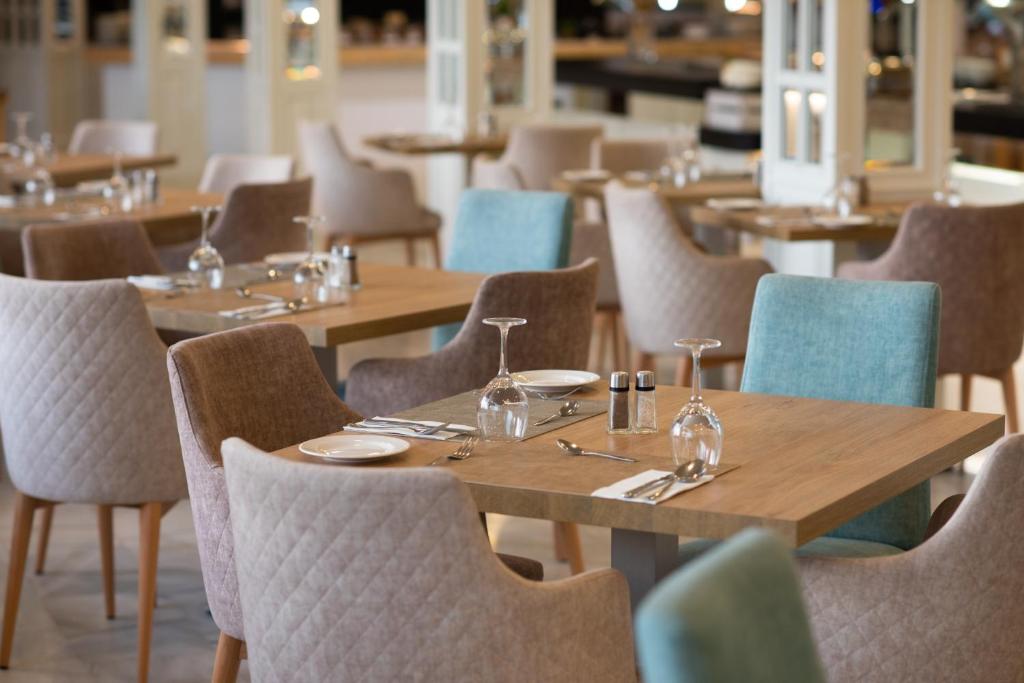 a dining room with wooden tables and chairs at Valentin Son Bou in Son Bou