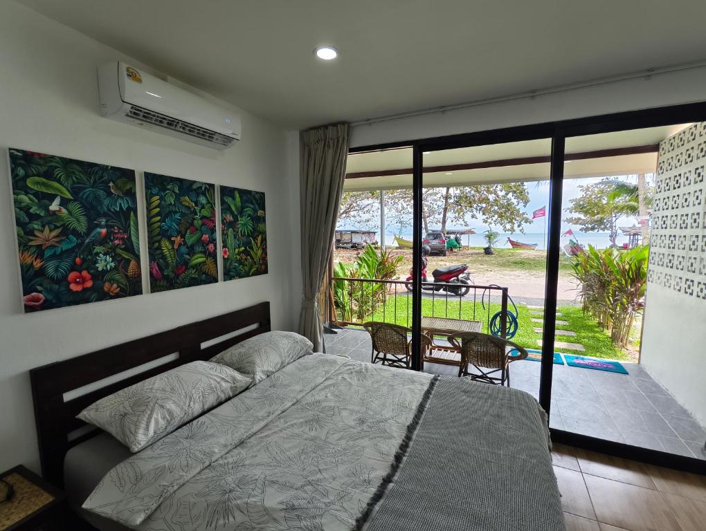 a bedroom with a bed and a balcony at Pavana Boutique & Kite Bungalows in Thongsala