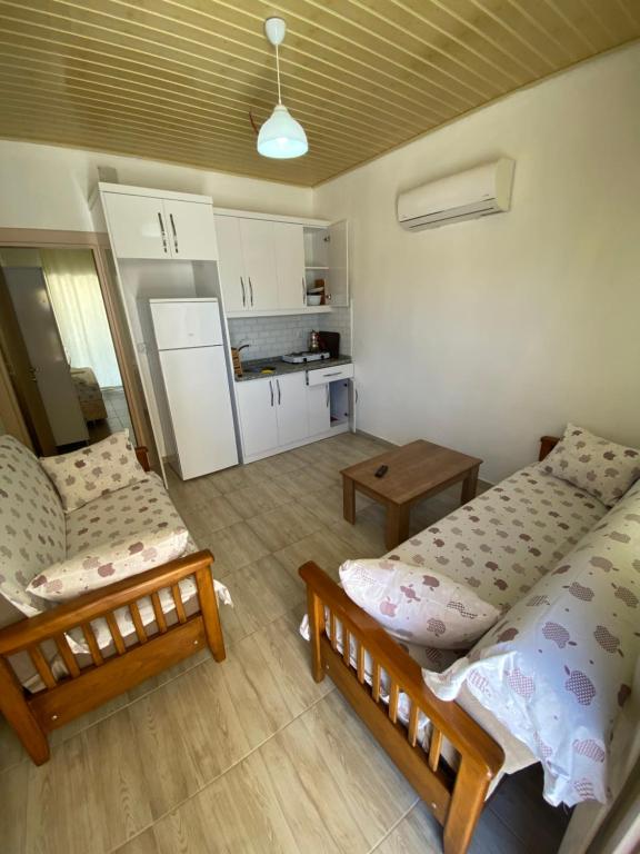 a living room with two beds and a kitchen at Göksel Apart in Mersin
