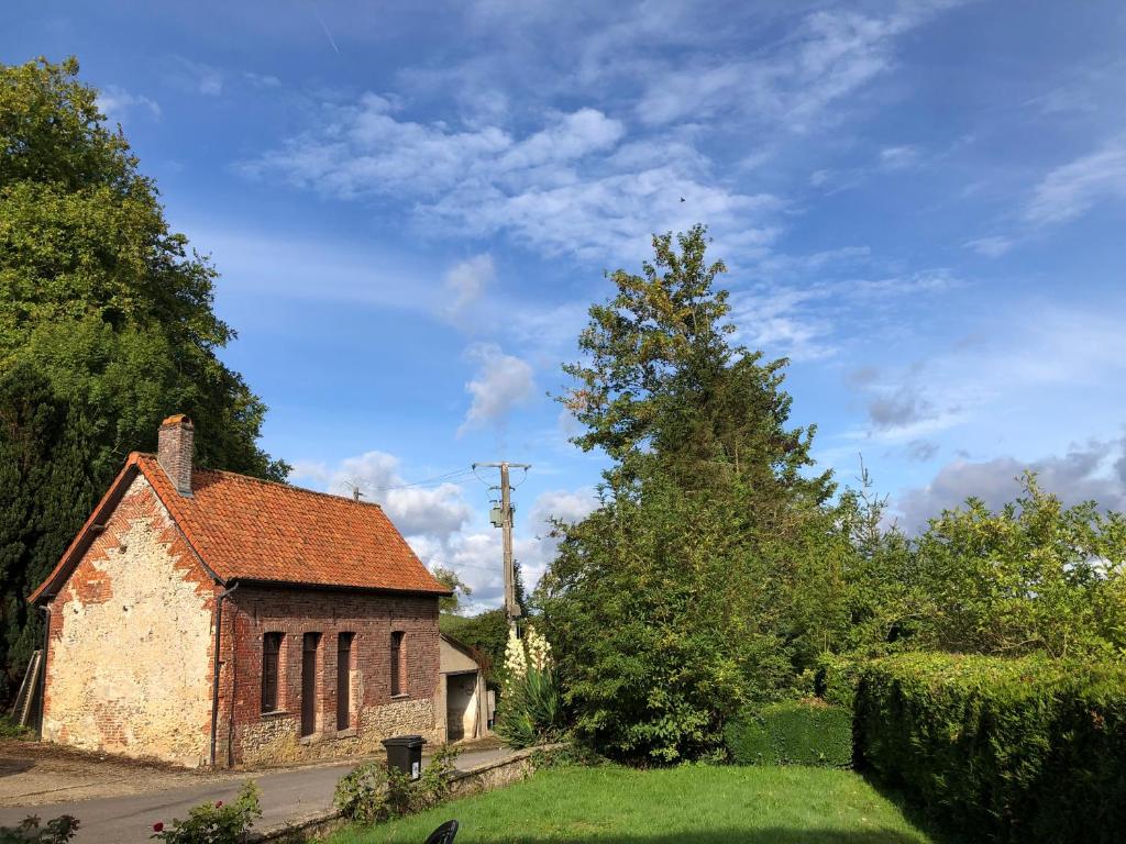 une vieille maison en briques dans une cour arborée dans l'établissement La ferme de Sidoine, à Beaumerie-Saint-Martin