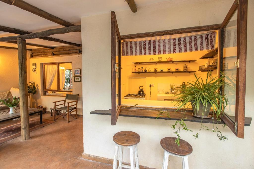 a room with two stools and a large window at Ol Losowan House and Cottages in Nairobi