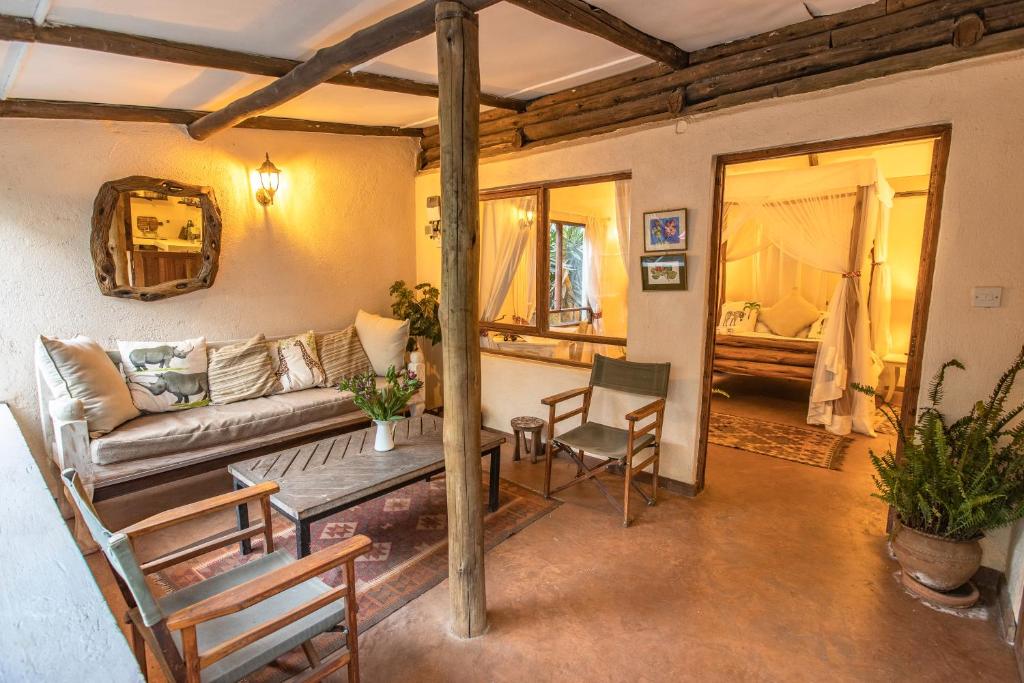 a living room with a couch and a table and chairs at Ol Losowan House and Cottages in Nairobi