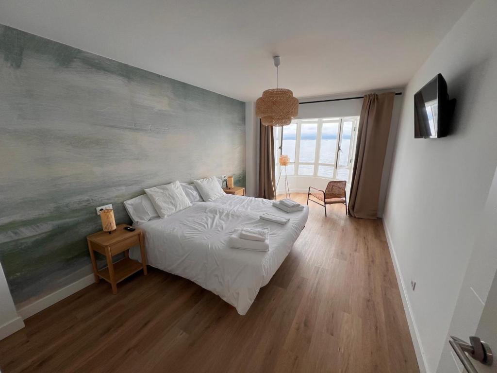 a bedroom with a bed and a painting on the wall at Ribeira Flats in Ribeira