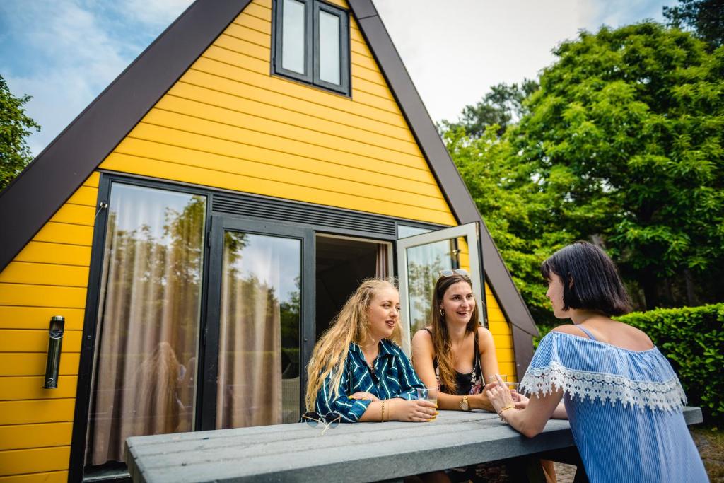 a group of three girls sitting on the porch of a tiny house at Gezellig vakantiehuis in Mol