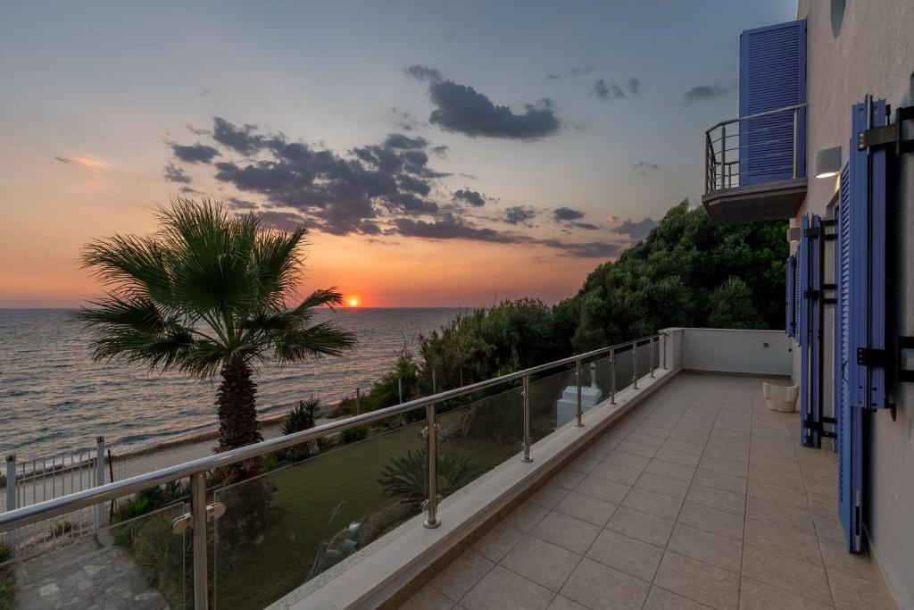 a balcony with a palm tree and a sunset at Casa Azzura in Mytikas