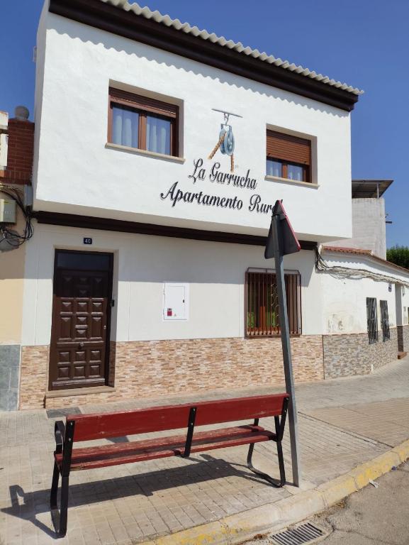 a red bench in front of a building at LA GARRUCHa in Argamasilla de Alba