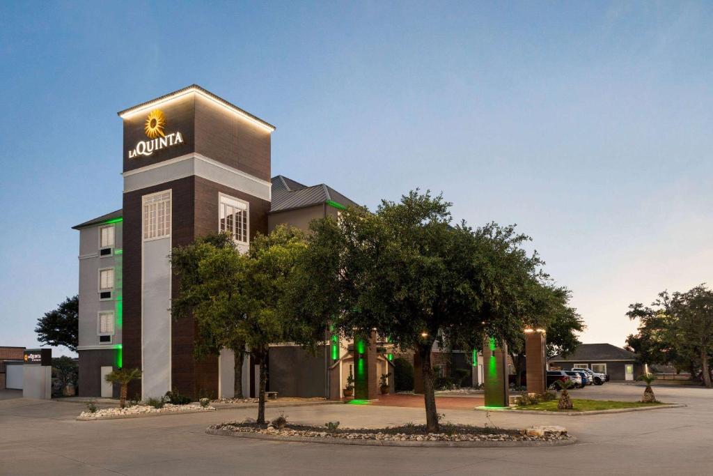 a building with aania sign on it in a parking lot at La Quinta by Wyndham San Antonio North Stone Oak in San Antonio