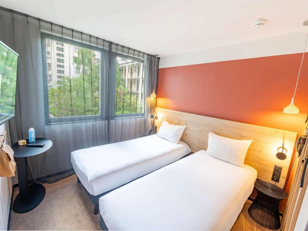 a hotel room with two beds and a window at ibis Styles Paris 16 Boulogne in Paris
