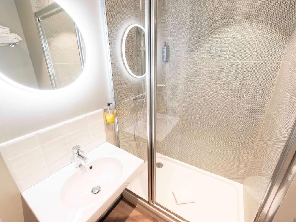 a white bathroom with a sink and a shower at ibis Styles Paris 16 Boulogne in Paris