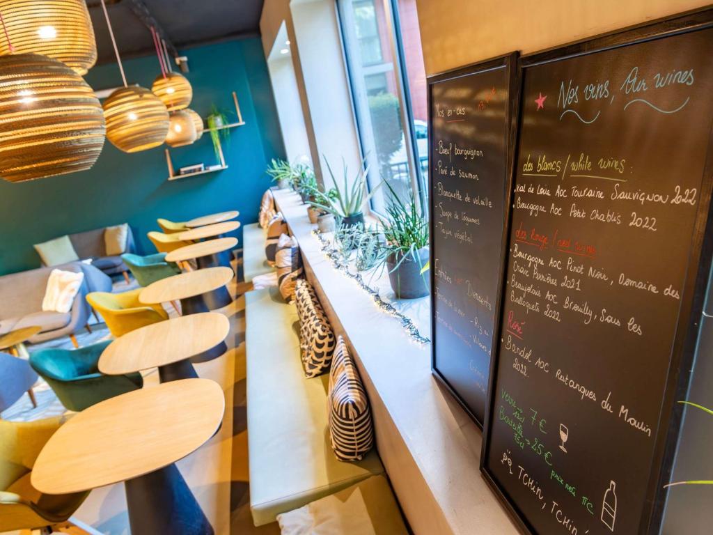 a restaurant with a chalkboard and tables and chairs at ibis Styles Paris 16 Boulogne in Paris