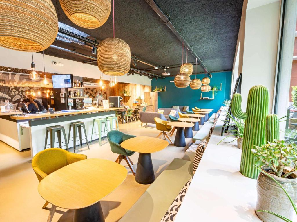 a restaurant with tables and chairs and a bar at ibis Styles Paris 16 Boulogne in Paris