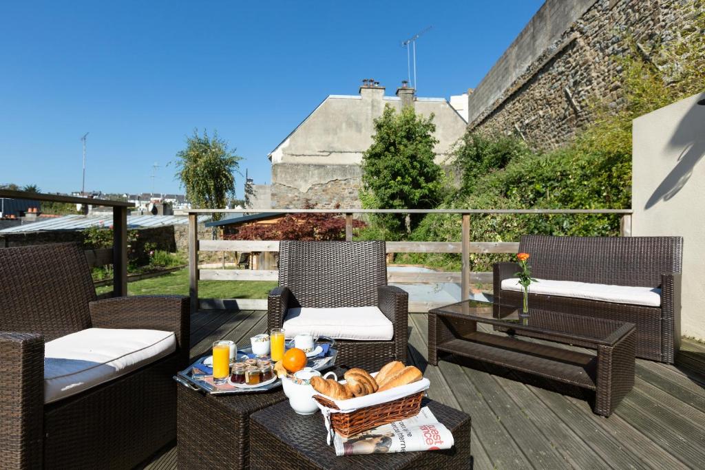 uma bandeja de comida numa mesa numa varanda em Hotel De Clisson Saint Brieuc em Saint-Brieuc