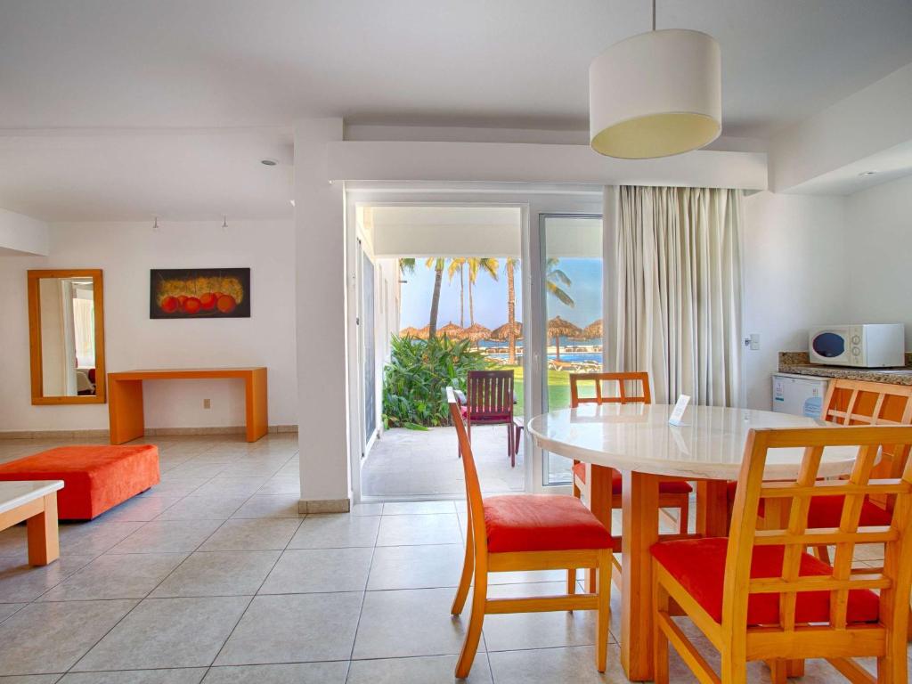 a kitchen and dining room with a table and chairs at Marival Emotions Resort & Suites Riviera Nayarit by Mercure in Nuevo Vallarta