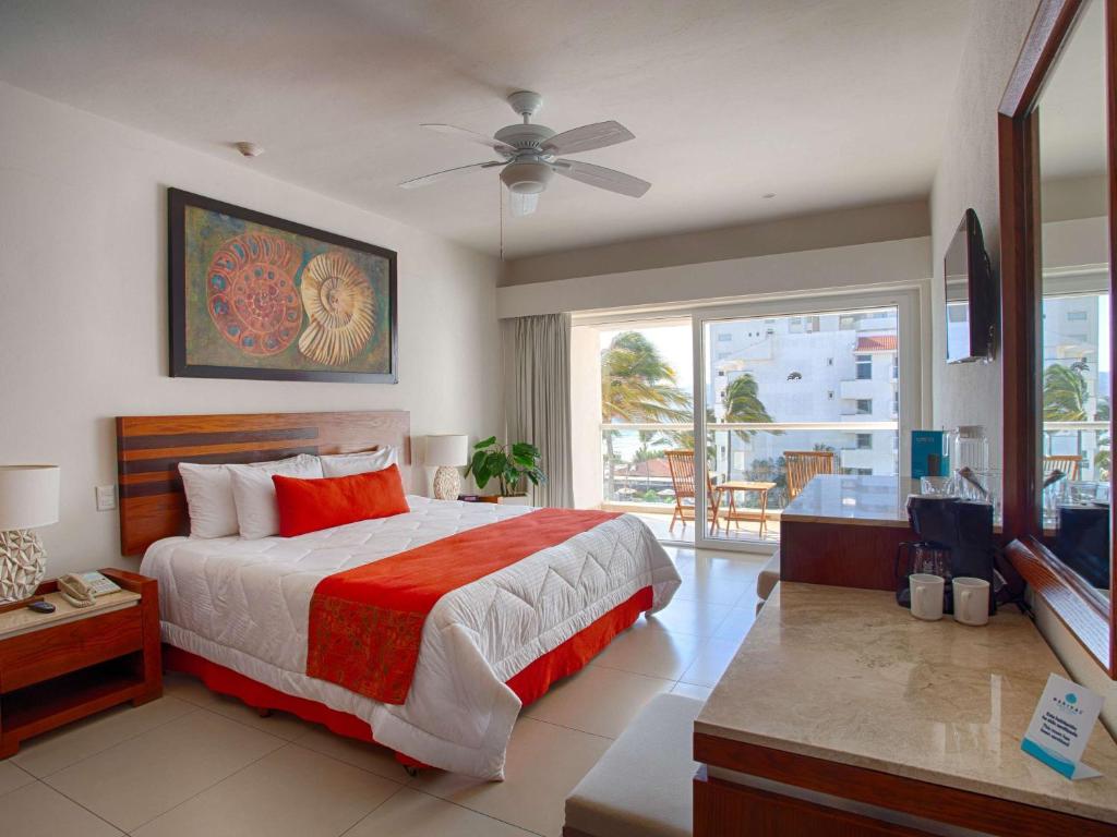 a bedroom with a large bed and a balcony at Marival Emotions Resort & Suites Riviera Nayarit by Mercure in Nuevo Vallarta