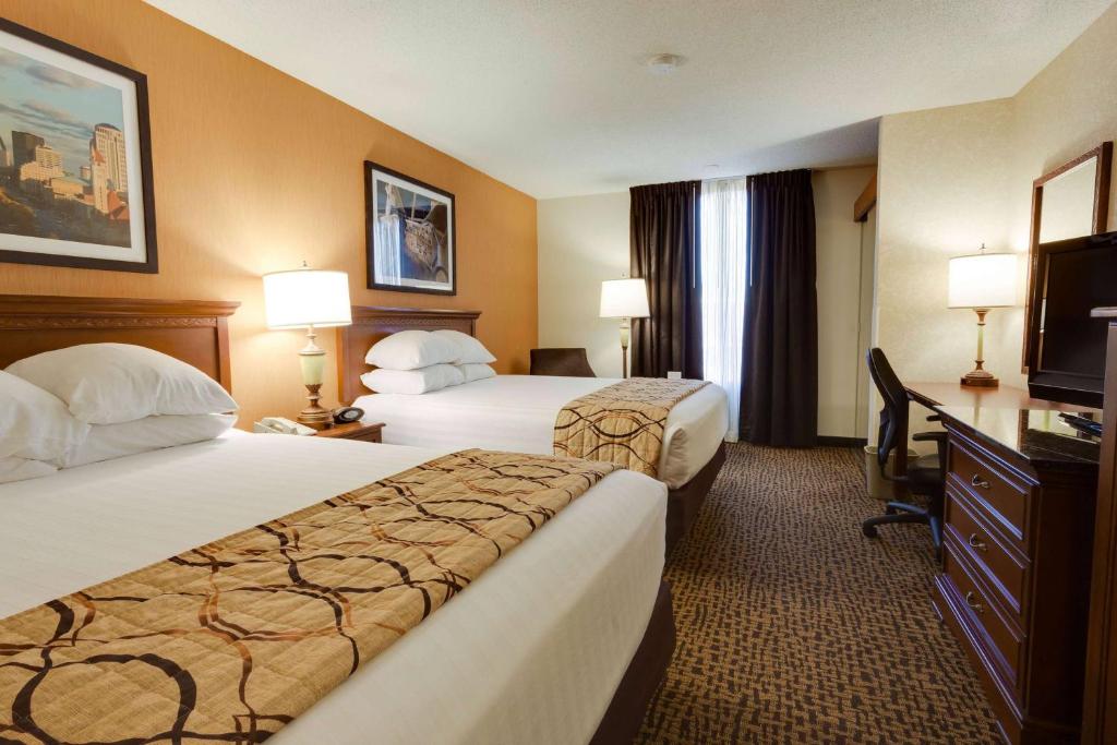 a hotel room with two beds and a television at Wingate by Wyndham St Louis-Fenton Route 66 in Fenton