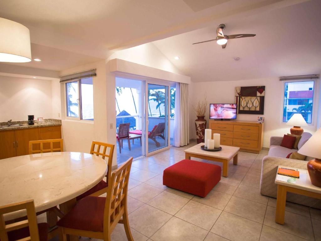 a living room with a table and a couch at Marival Emotions Resort & Suites Riviera Nayarit by Mercure in Nuevo Vallarta