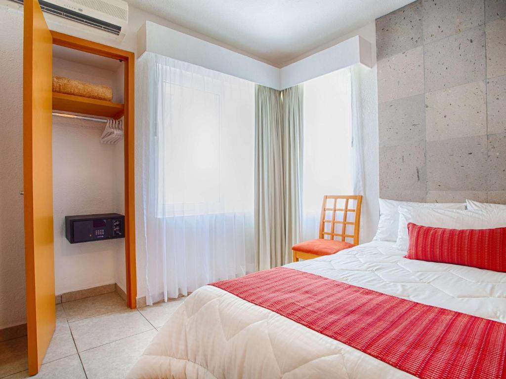a bedroom with a large bed and a window at Marival Emotions Resort & Suites Riviera Nayarit by Mercure in Nuevo Vallarta