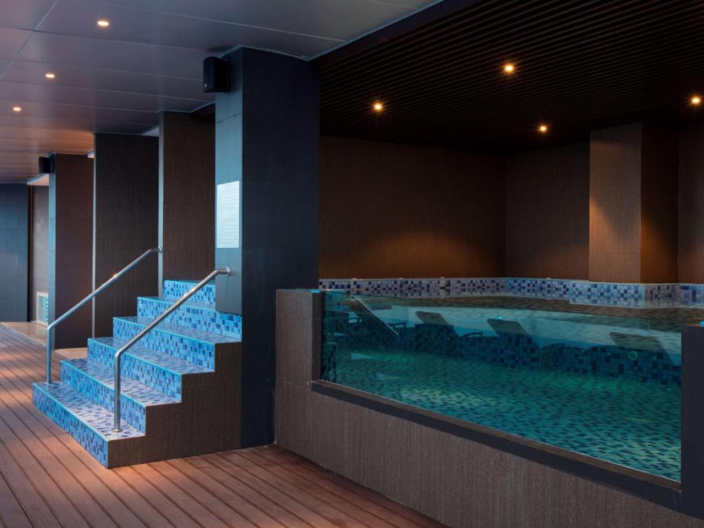 a large swimming pool with stairs and a swimming pool at Wyndham Panbil Batam in Batam Center