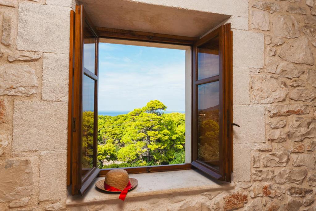 a window with a hat and a red ribbon at Villa Ampeli in Vasilikos