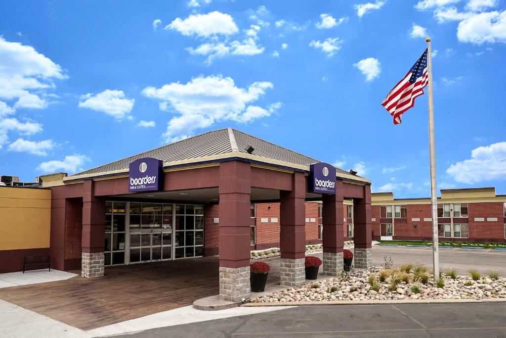 a building with an american flag in front of it at Boarders Inn & Suites by Cobblestone Hotels - Grand Island in Grand Island