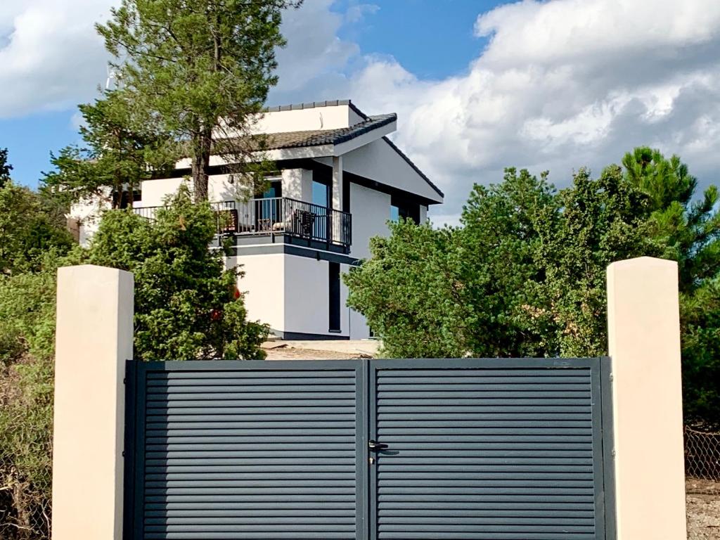 Chalet a estrenar, espectaculares vistas a la montaña في Torremocha de Jarama: منزل على تلة مع بوابة