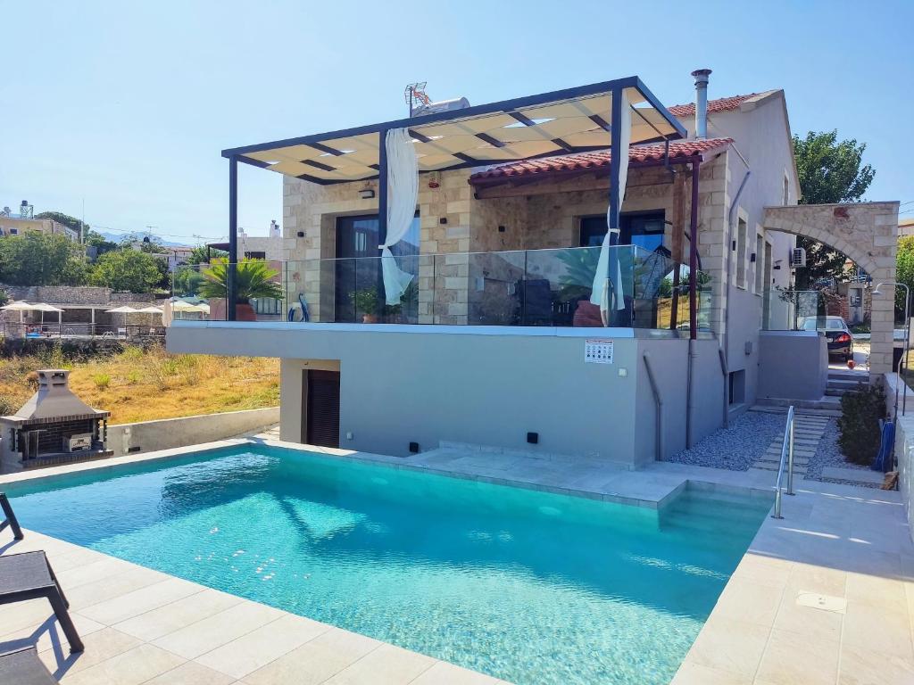 a villa with a swimming pool and a house at Villa ArGia with private pool in Georgioupoli