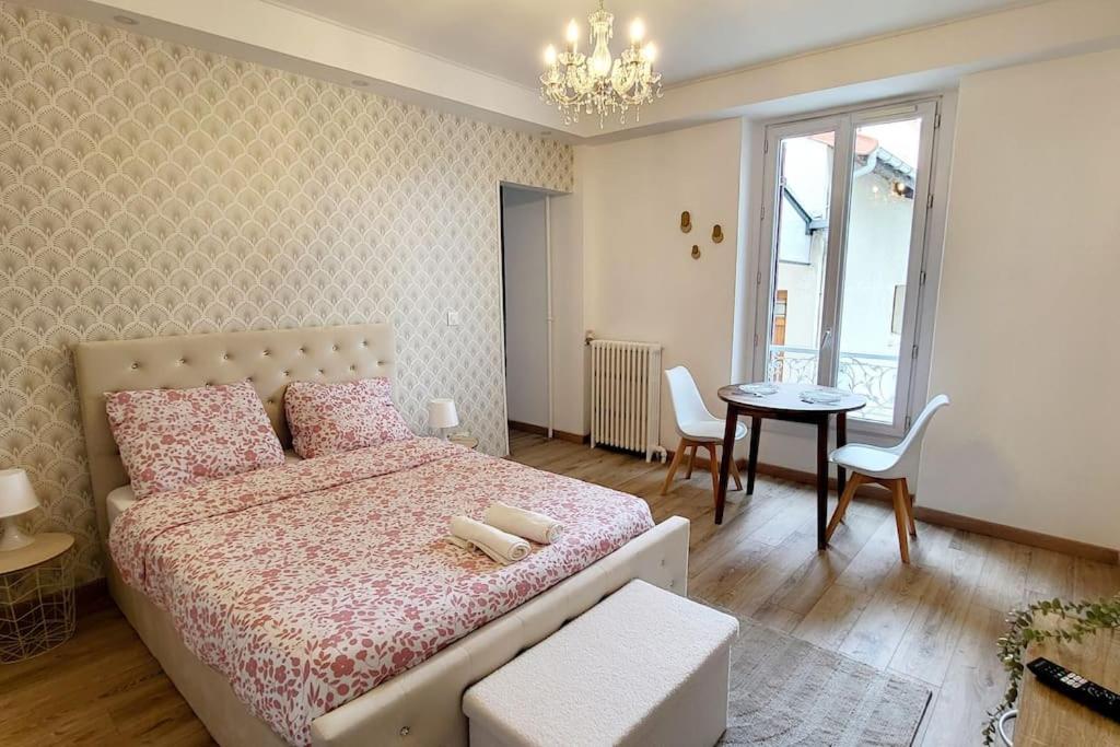 a bedroom with a bed and a table with chairs at Le Royal, proche Paris & Disney in Noisy-le-Grand