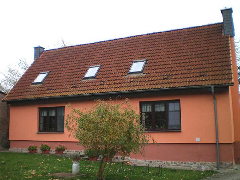a orange house with a brown roof at Ferienwohnungen auf dem Lande in Kittendorf