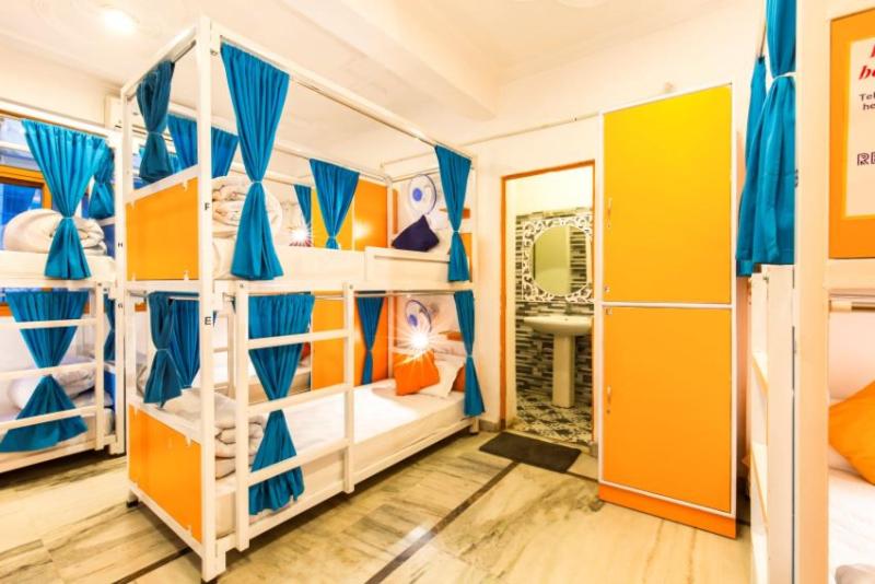 a bedroom with bunk beds with blue and yellow at ZoukStayz in Rishīkesh