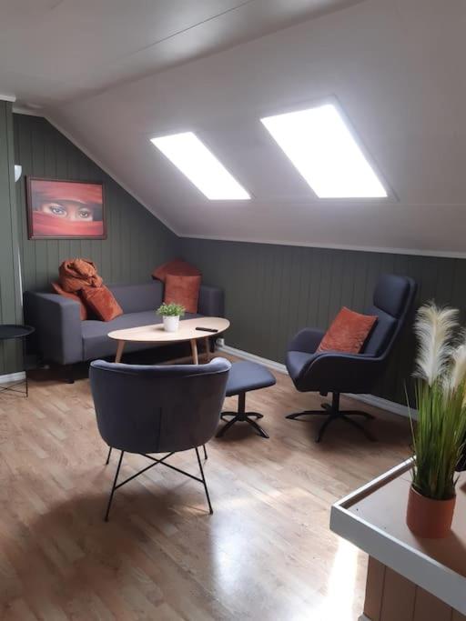 a room with couches and a table and chairs at 2 etasje Jutulveien 6 in Tønsberg