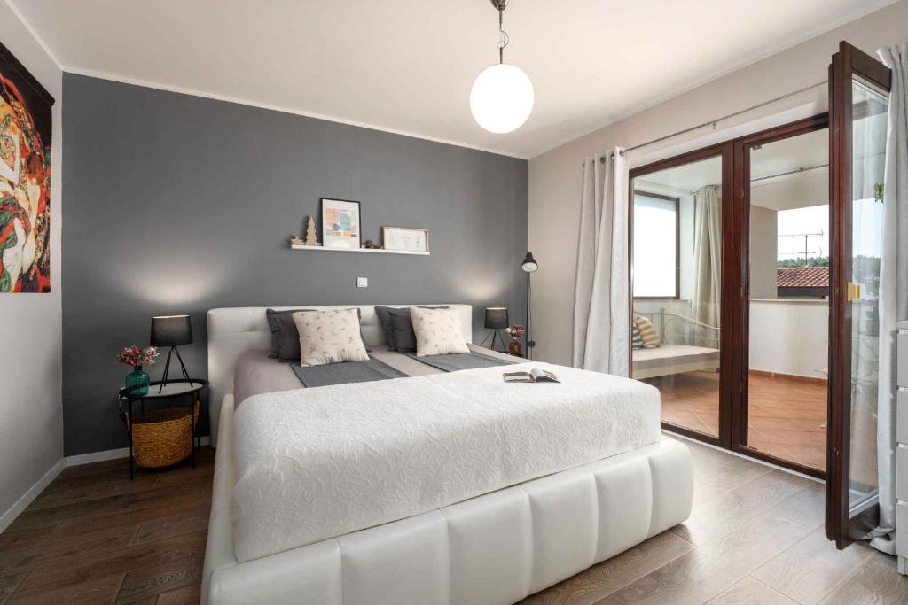 sypialnia z białym łóżkiem i przesuwnymi szklanymi drzwiami w obiekcie Holiday home in Porec - Istrien 27453 w Poreču